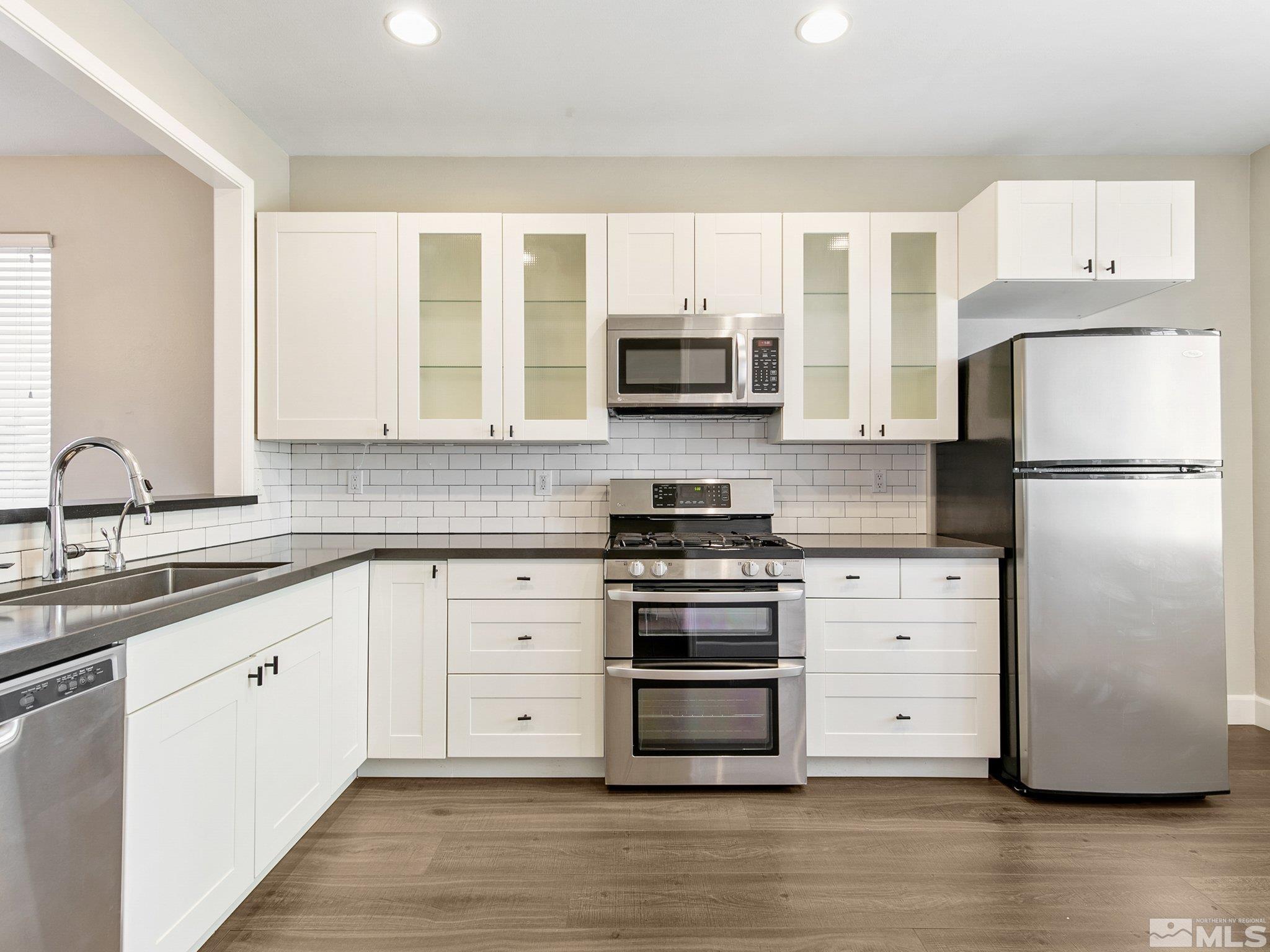 2348 Clementine Lane Reno, NV 89521 - Photo 10 of 38 a kitchen with stainless steel appliances white cabinets and a refrigerator