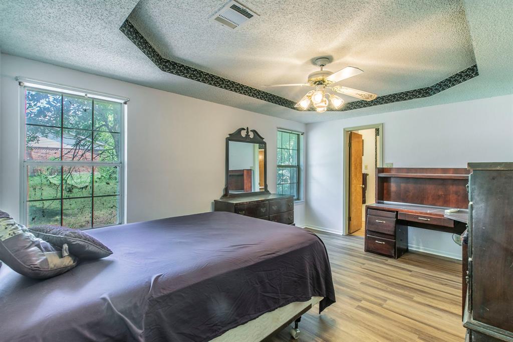 1936 Post Oak Drive Waco, TX 76705 - Photo 14 of 33 Bedroom with wood finished floors, a textured ceiling, ceiling fan, and a raised ceiling