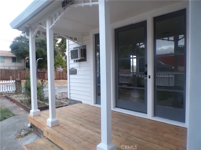 a view of a hallway with wooden floor and a room