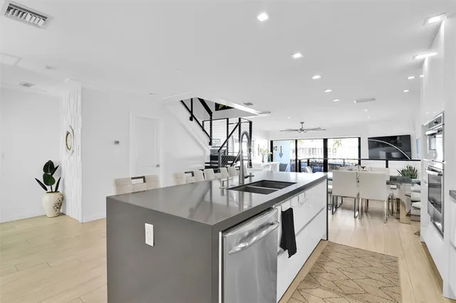 a kitchen with stainless steel appliances a table chairs refrigerator and microwave