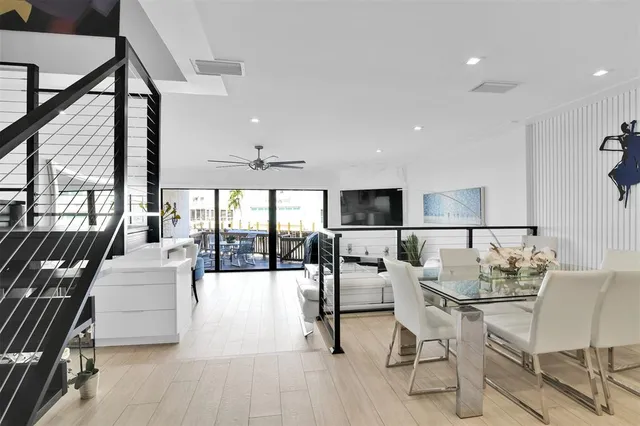 a living room with furniture a large window and stainless steel appliances