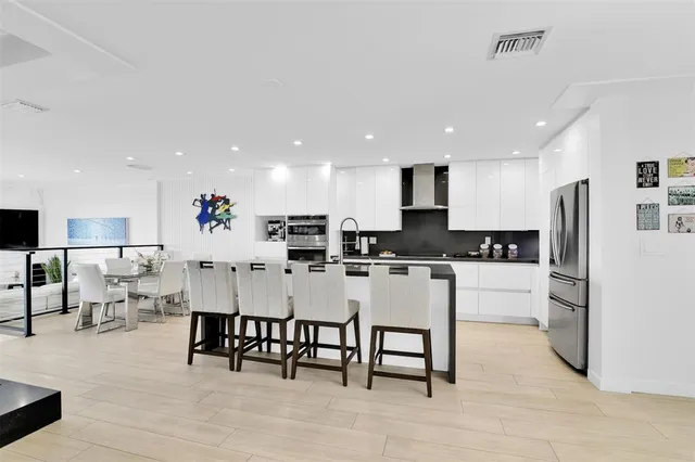 a large white kitchen with white cabinets and stainless steel appliances