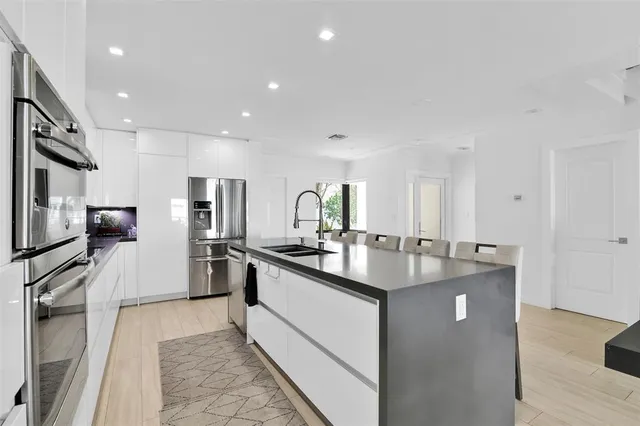 a kitchen with stainless steel appliances granite countertop a sink stove and refrigerator