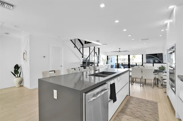a large white kitchen with lots of counter space and dining table