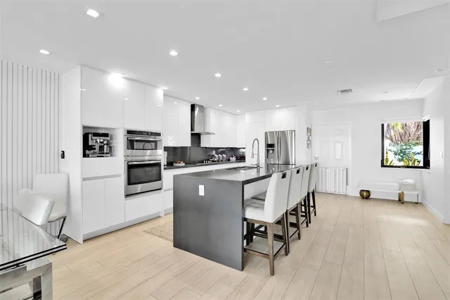 a kitchen with stainless steel appliances granite countertop a sink stove and refrigerator