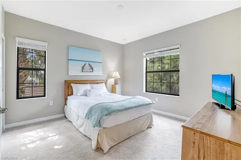 a bedroom with a bed a couch and potted plant