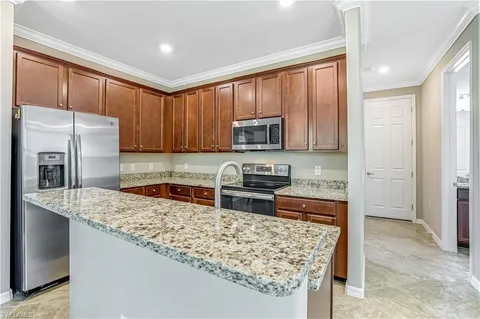 a kitchen with stainless steel appliances granite countertop a stove top oven a sink dishwasher and a refrigerator