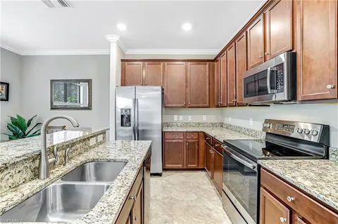a kitchen with stainless steel appliances granite countertop a stove refrigerator and a sink