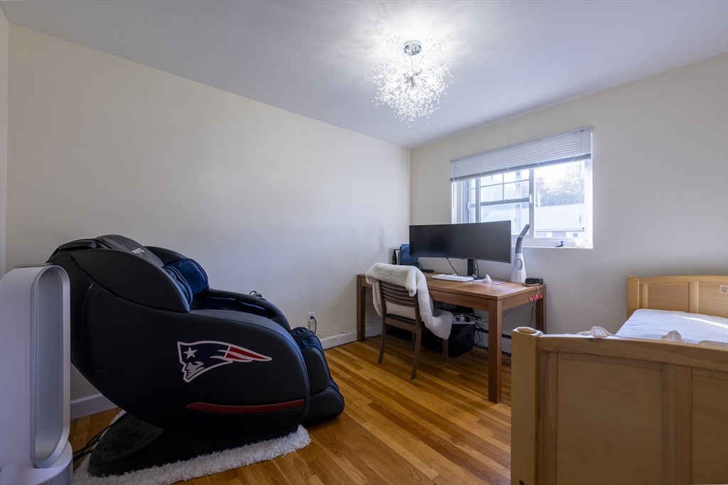 18 Emerson Gardens Road, Unit 18 Lexington, MA 02420 - Photo 12 of 23 a living room with furniture and a chandelier