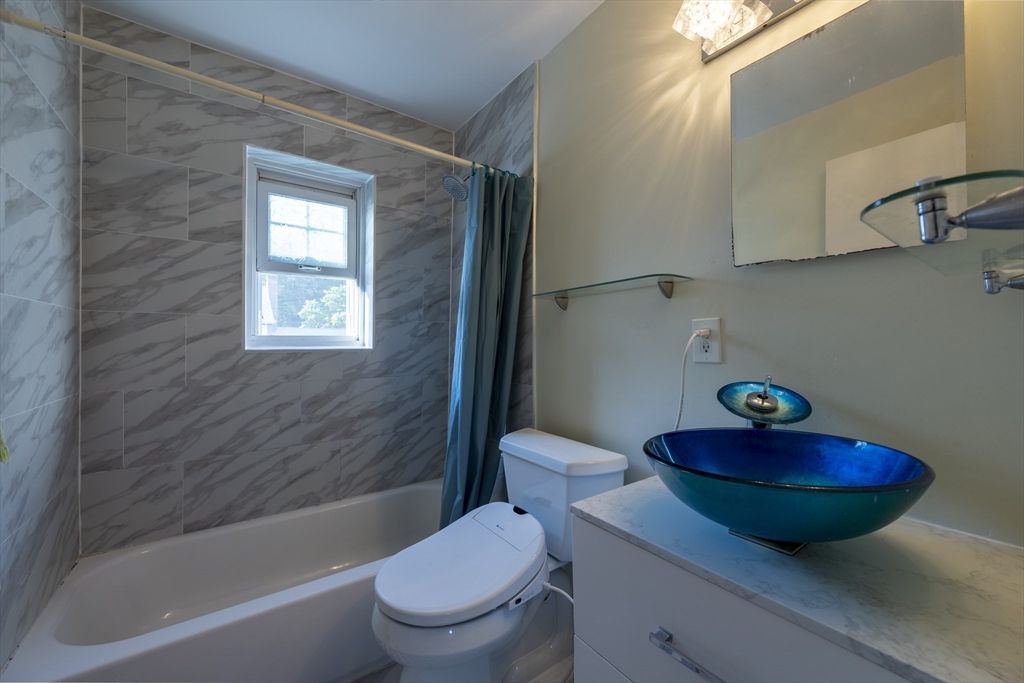 18 Emerson Gardens Road, Unit 18 Lexington, MA 02420 - Photo 14 of 23 a bathroom with a sink a mirror and a toilet