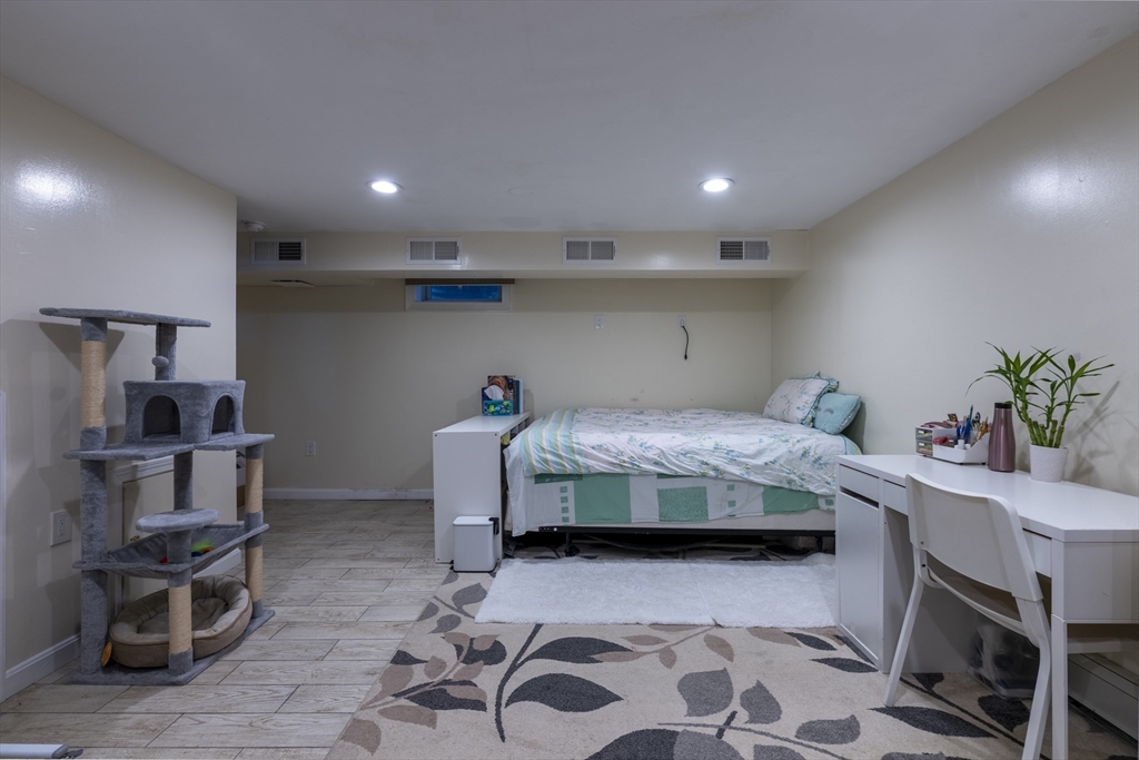 18 Emerson Gardens Road, Unit 18 Lexington, MA 02420 - Photo 16 of 23 a bedroom with a bed a table and chair