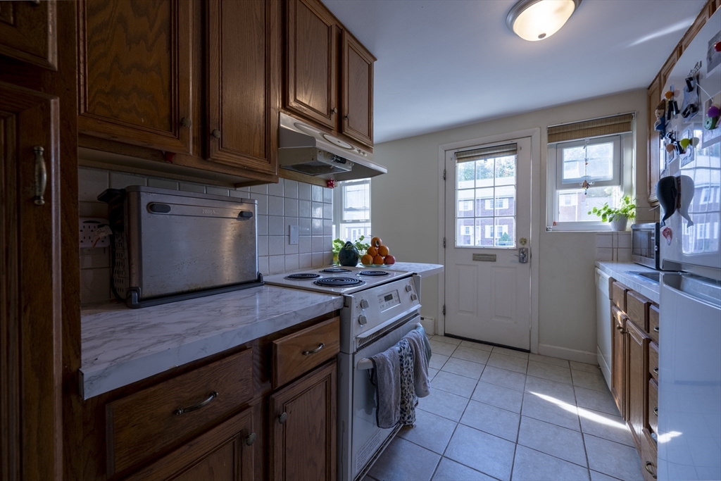 18 Emerson Gardens Road, Unit 18 Lexington, MA 02420 - Photo 19 of 23 a kitchen with stainless steel appliances granite countertop a stove and a sink