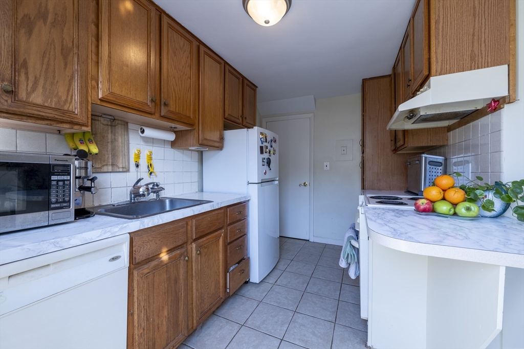 18 Emerson Gardens Road, Unit 18 Lexington, MA 02420 - Photo 6 of 23 a kitchen with stainless steel appliances granite countertop a sink a stove and cabinets
