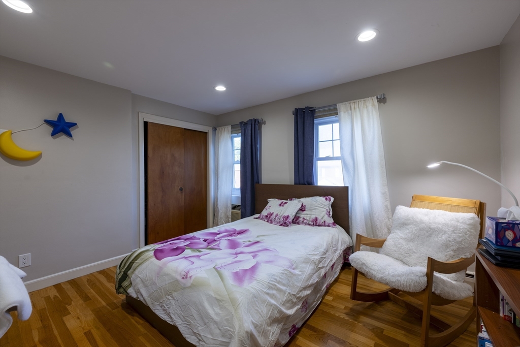 18 Emerson Gardens Road, Unit 18 Lexington, MA 02420 - Photo 10 of 23 a bedroom with a bed and wooden floor