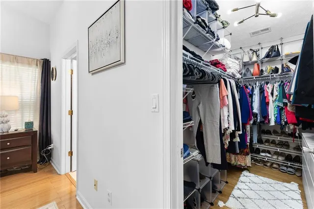 a view of walk in closet with clothes and shoes