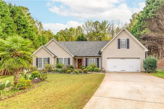 a front view of house with yard and trees around