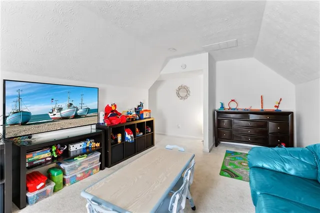 a living room with furniture and a baby crib