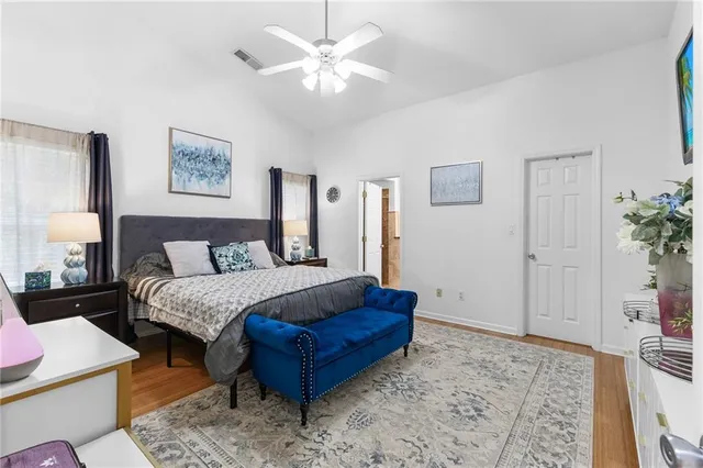 a spacious bedroom with a bed a couch and potted plant on the table