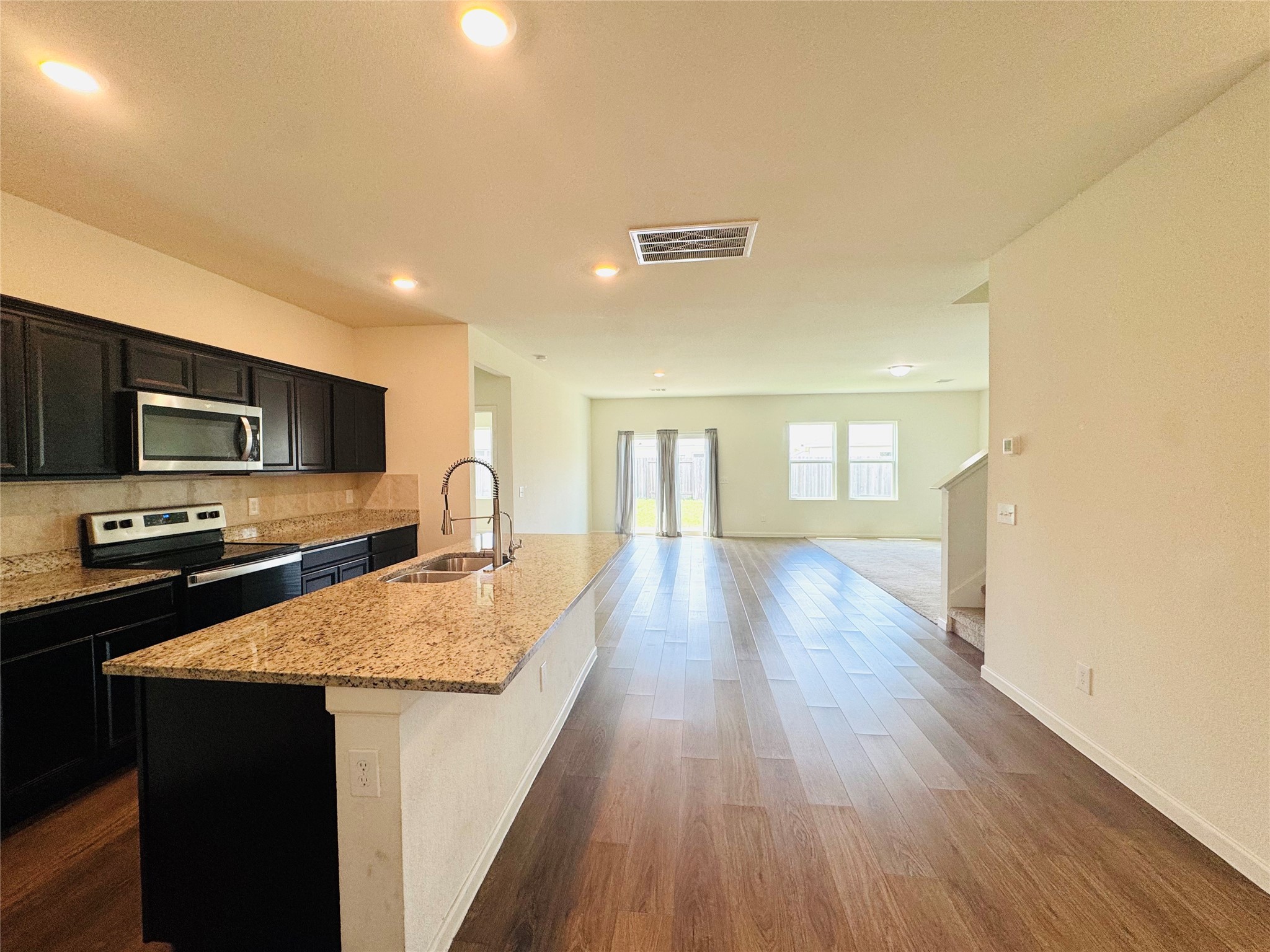 1013 Pitch Pine Brookshire, TX 77423 - Photo 8 of 30 a large kitchen with stainless steel appliances granite countertop a lot of counter space and wooden floor
