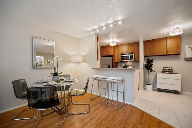 a kitchen with stainless steel appliances kitchen island granite countertop a stove a sink a dining table and chairs