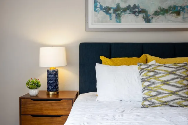 a bedroom with a bed and painting on the wall