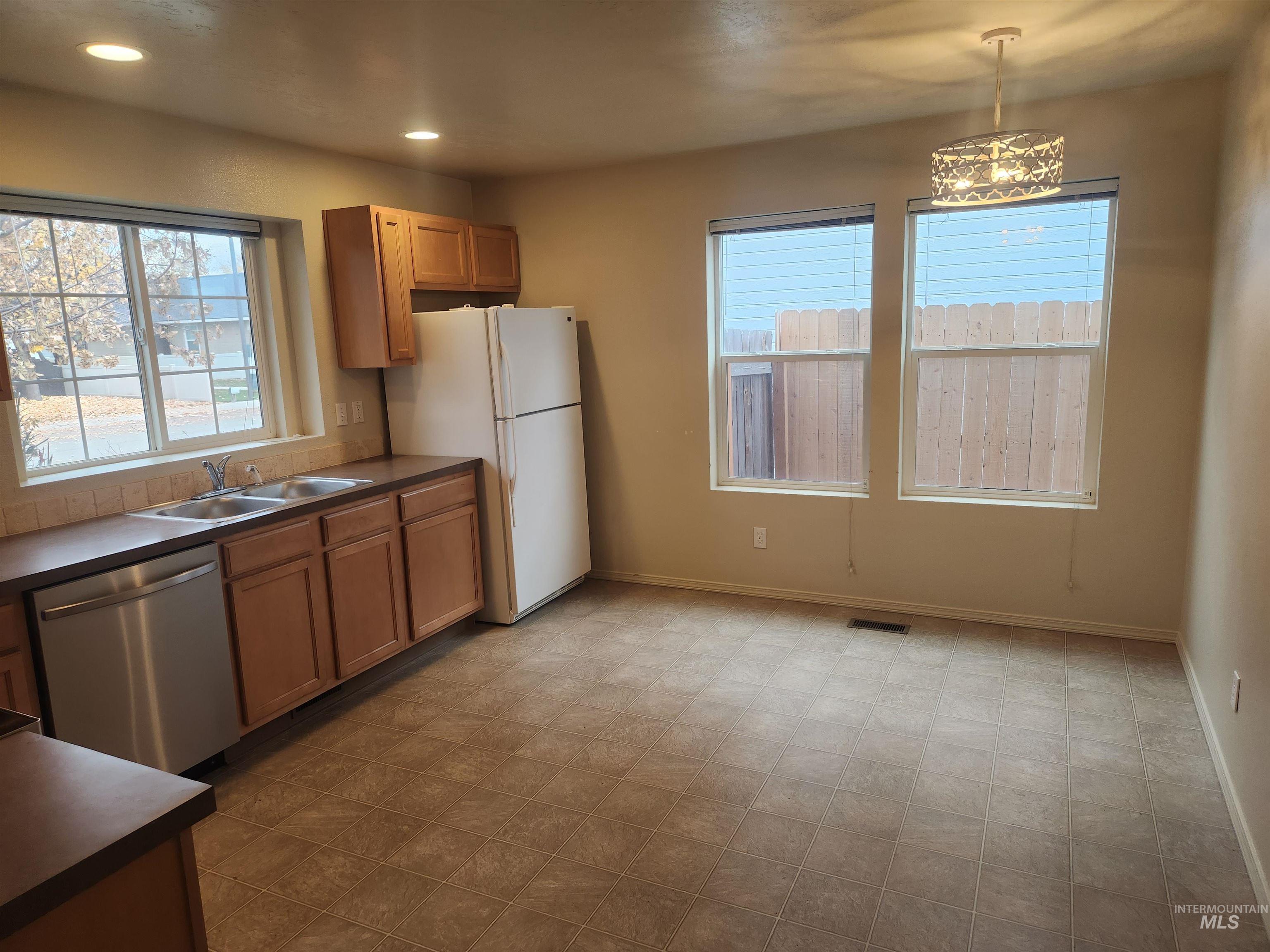 9962 West Rustica Street Boise, ID 83709 - Photo 4 of 15 Kitchen with white appliances, recessed lighting, dark countertops, and light carpet