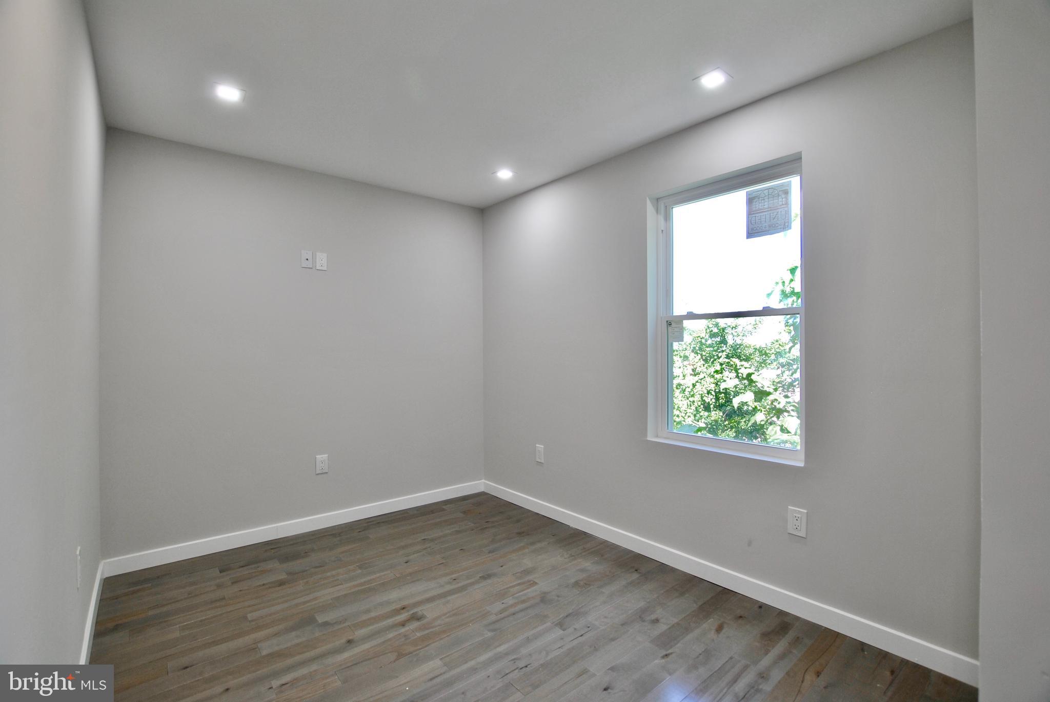 2153 North 19th Street, Unit 4 Philadelphia, PA 19121 - Photo 13 of 17 an empty room with wooden floor and windows