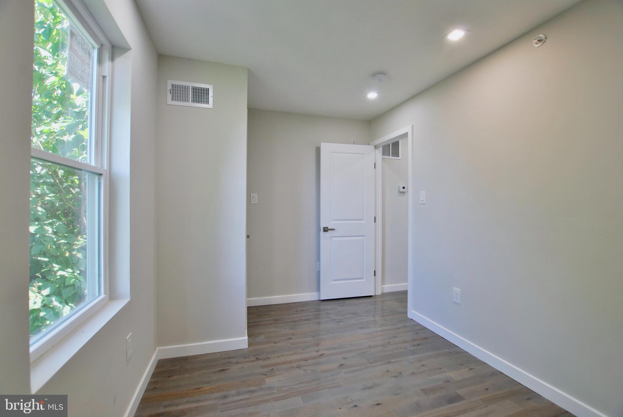 2153 North 19th Street, Unit 4 Philadelphia, PA 19121 - Photo 14 of 17 a view of an empty room with wooden floor and a window