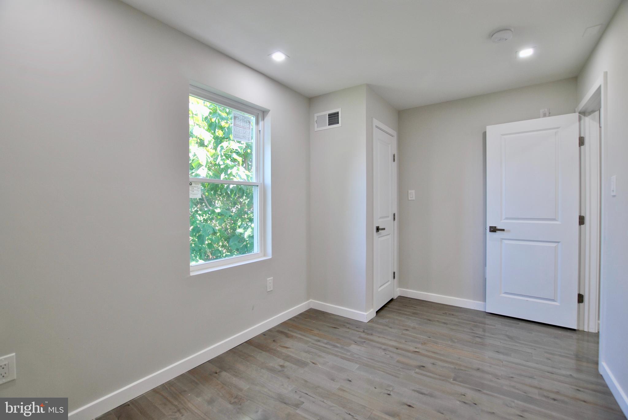 2153 North 19th Street, Unit 4 Philadelphia, PA 19121 - Photo 8 of 17 a view of an empty room with wooden floor and a window
