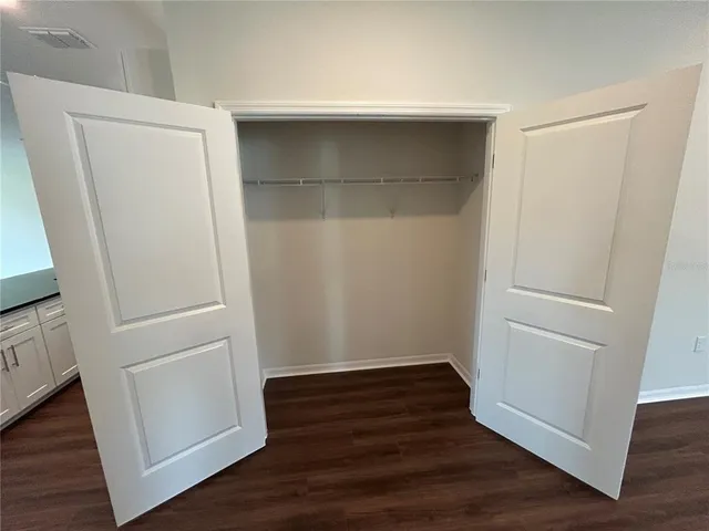 an empty room with wooden floor and white doors
