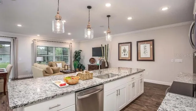 a kitchen with granite countertop a sink and a wooden floor
