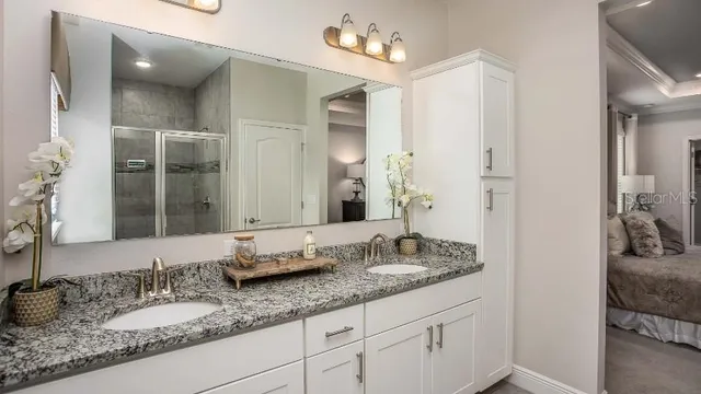 a bathroom with a granite countertop sink and a mirror