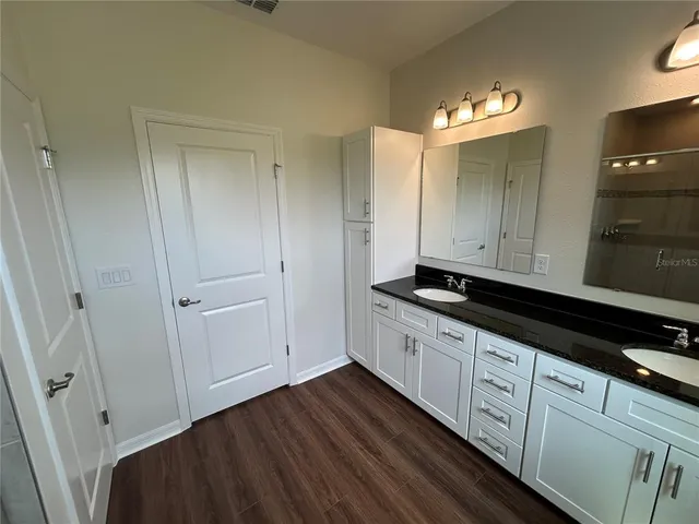 a kitchen with granite countertop white cabinets and a sink