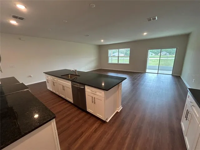 a kitchen with granite countertop a stove and wooden floor