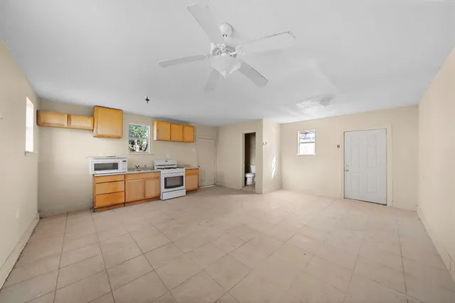 a view of kitchen with stainless steel appliances cabinets and a window