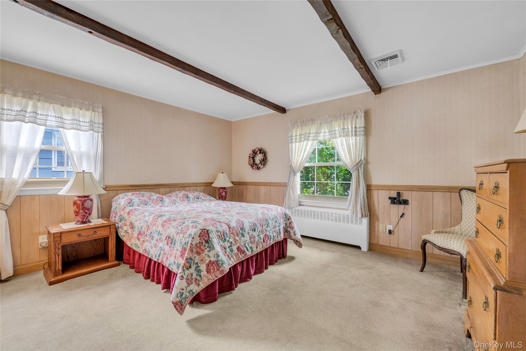 21 Farragut Road Old Bethpage, NY 11804 - Photo 11 of 22 Carpeted bedroom featuring wood walls, a wainscoted wall, radiator heating unit, and beam ceiling