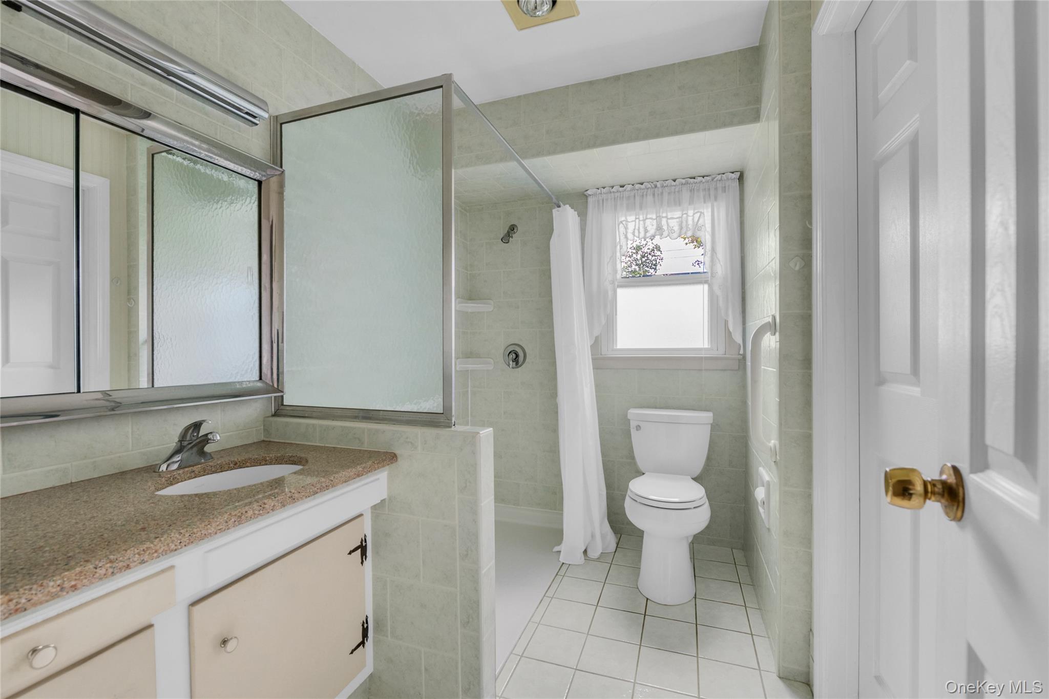 21 Farragut Road Old Bethpage, NY 11804 - Photo 12 of 22 Full bathroom featuring tile walls, light tile patterned flooring, vanity, and a shower stall