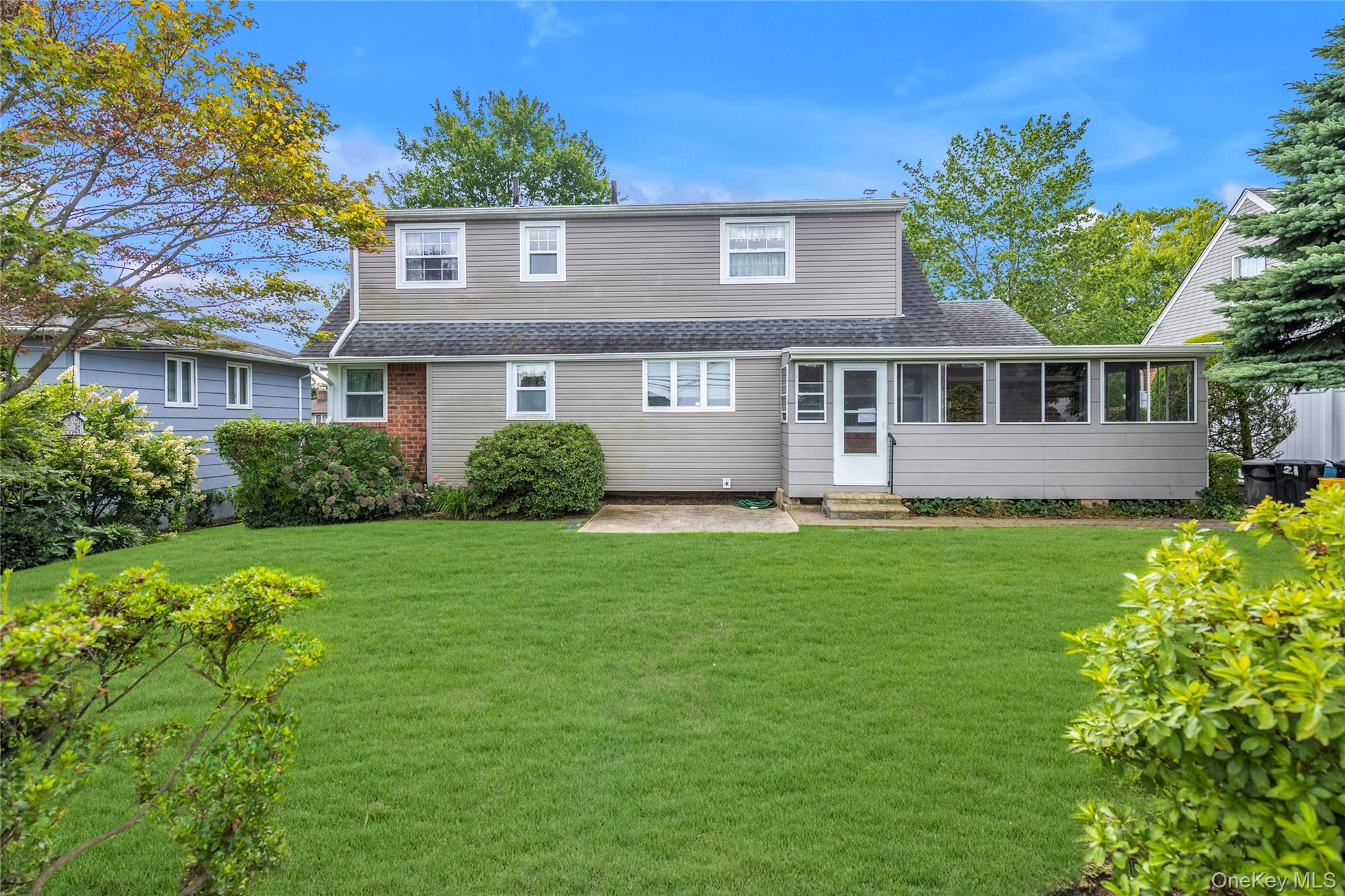 21 Farragut Road Old Bethpage, NY 11804 - Photo 20 of 22 Back of property with a sunroom, a yard, a shingled roof, and entry steps