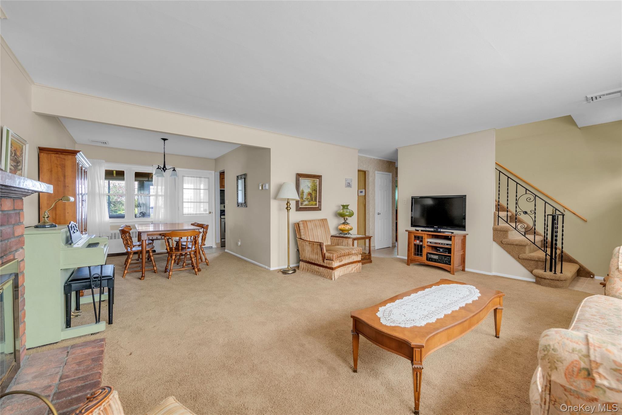 21 Farragut Road Old Bethpage, NY 11804 - Photo 5 of 22 Carpeted living room featuring a brick fireplace and stairs
