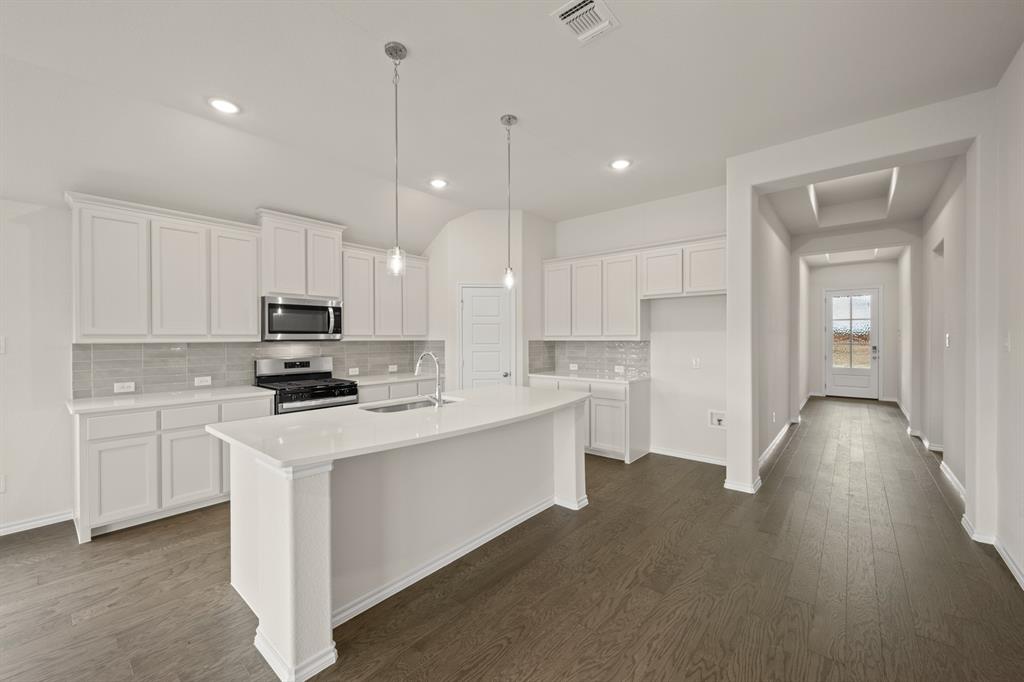 10809 Rothland Street Crowley, TX 76036 - Photo 4 of 30 a kitchen with white cabinets and stainless steel appliances