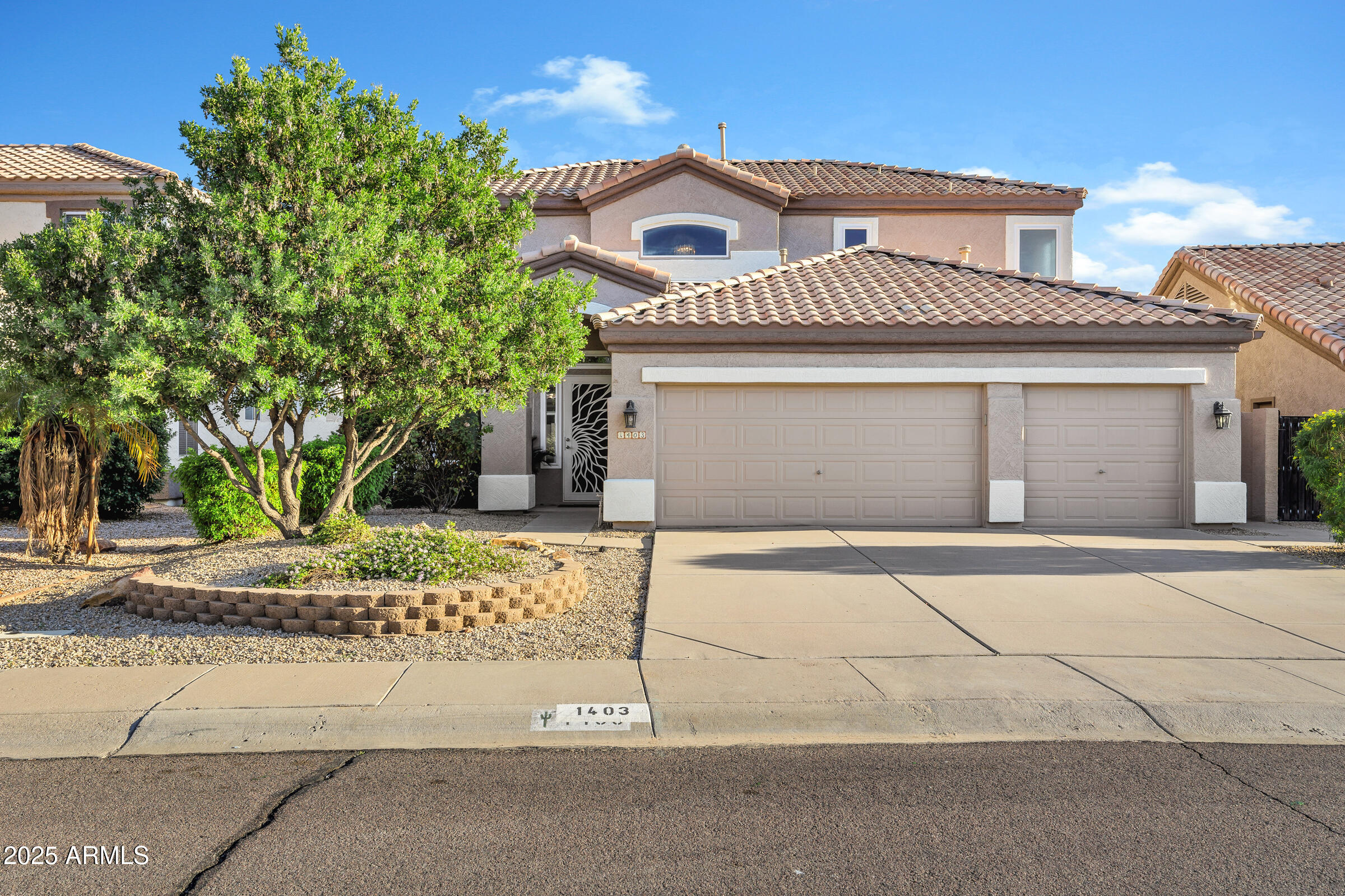 1403 West Windhaven Avenue Gilbert, AZ 85233 - Photo 1 of 64 a front view of a house with a garden