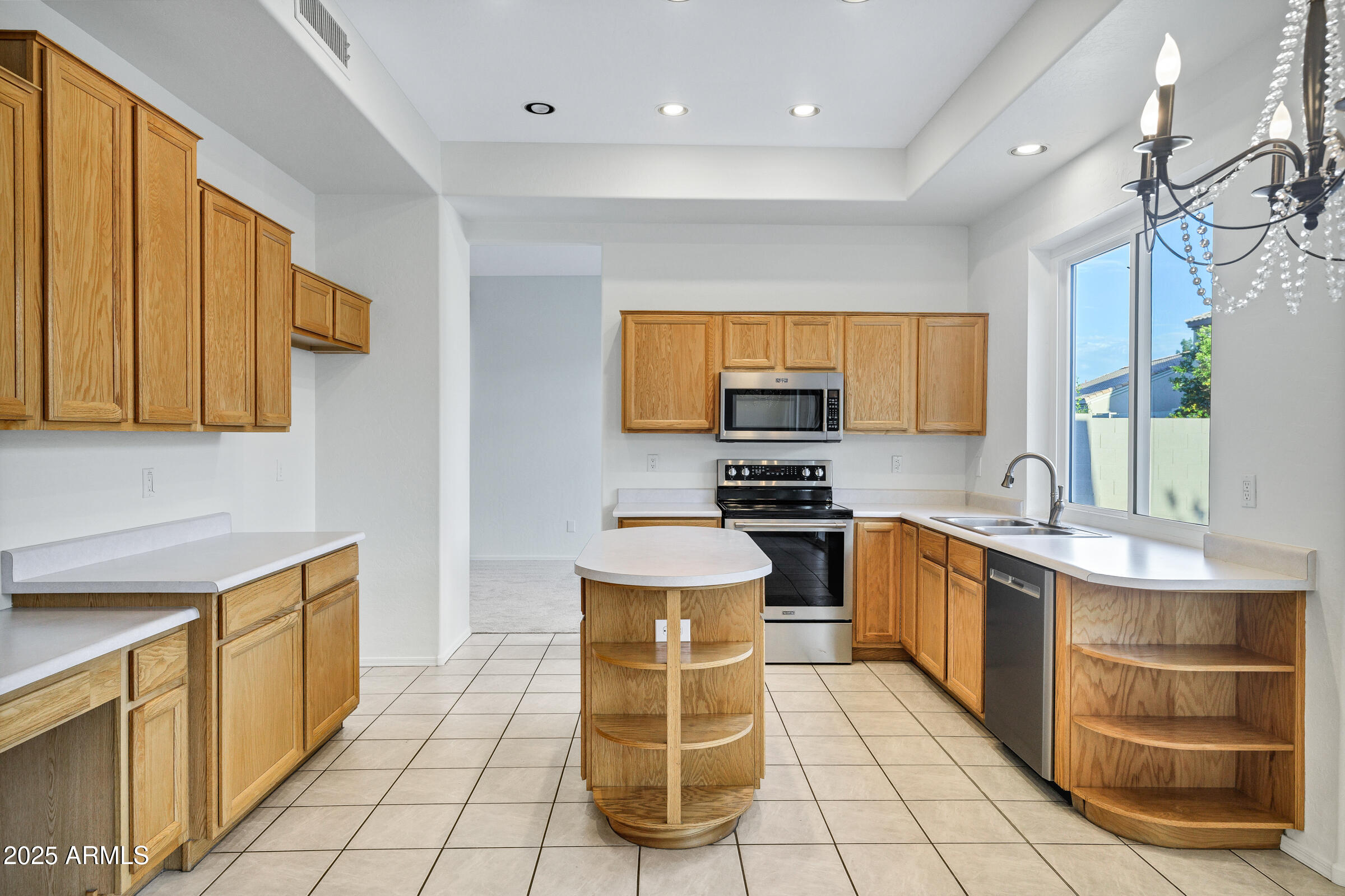 1403 West Windhaven Avenue Gilbert, AZ 85233 - Photo 19 of 64 a kitchen with stainless steel appliances granite countertop a stove a sink and a microwave