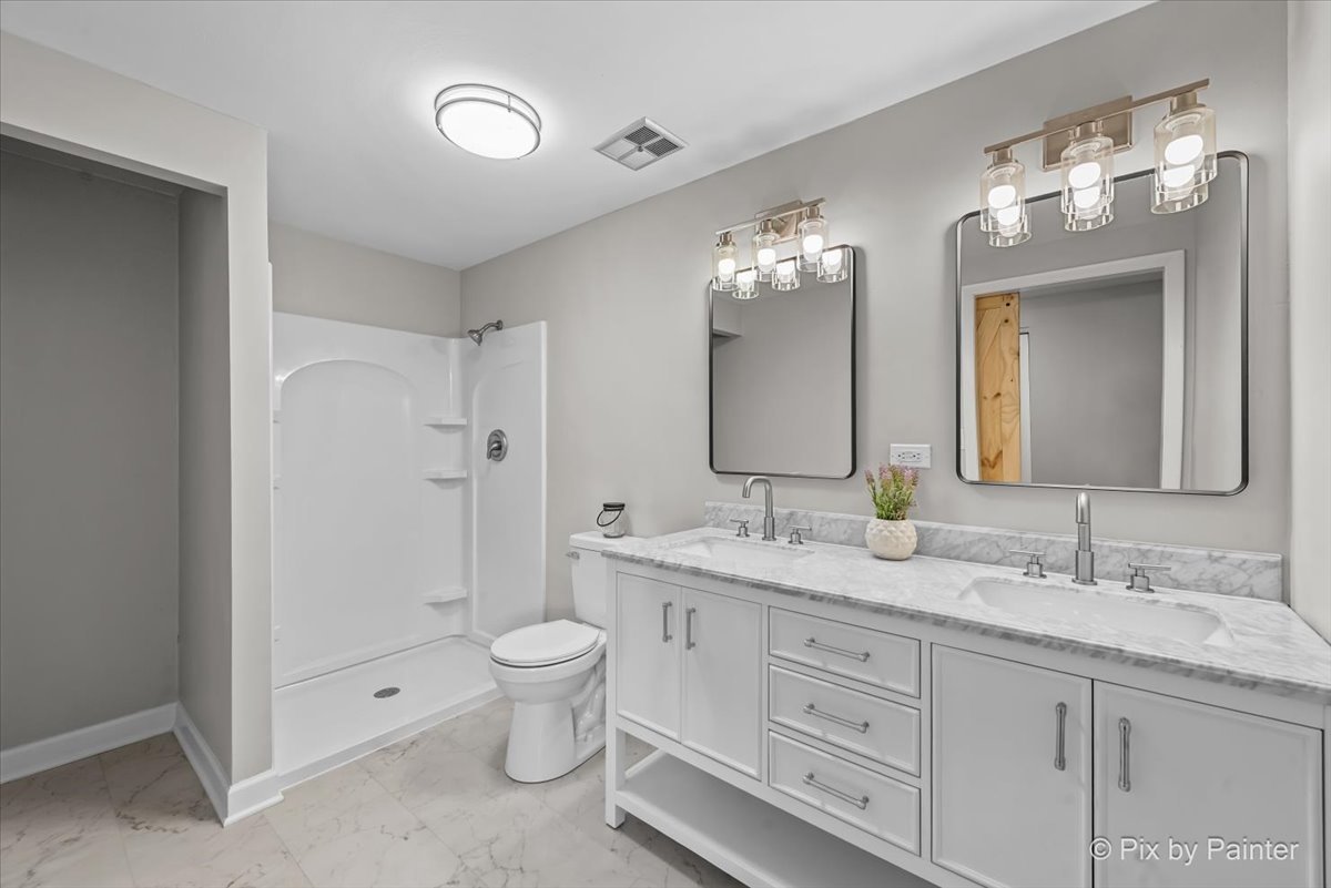 415 Laconia Court Schaumburg, IL 60193 - Photo 21 of 36 a spacious bathroom with a granite countertop sink a toilet and a large mirror