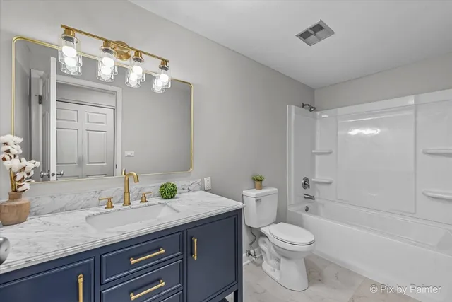 a bathroom with a granite countertop sink a toilet and shower