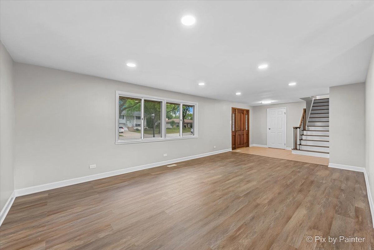 415 Laconia Court Schaumburg, IL 60193 - Photo 4 of 36 an empty room with wooden floor and windows