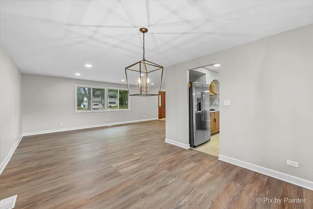 a view of a kitchen with a refrigerator a ceiling fan and wooden floor