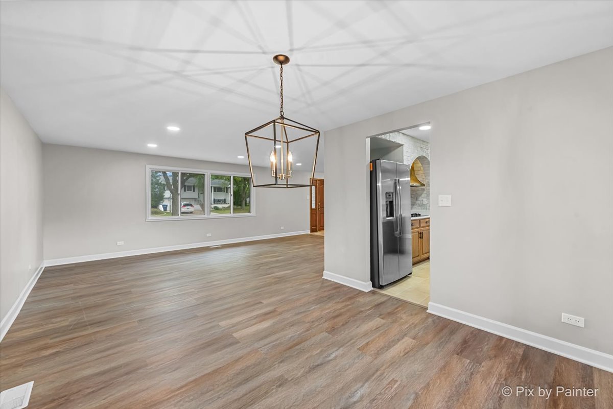 415 Laconia Court Schaumburg, IL 60193 - Photo 7 of 36 a view of a kitchen with a refrigerator a ceiling fan and wooden floor
