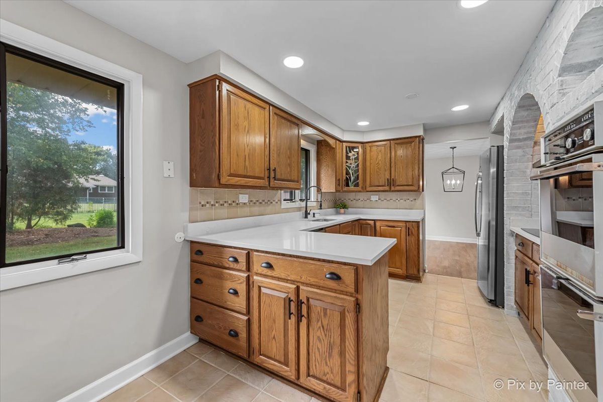 415 Laconia Court Schaumburg, IL 60193 - Photo 9 of 36 a kitchen with granite countertop a stove a sink and a refrigerator