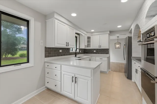 a kitchen with granite countertop a sink stainless steel appliances and cabinets