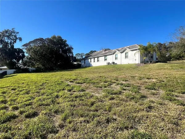 a view of a big yard with a house in the background